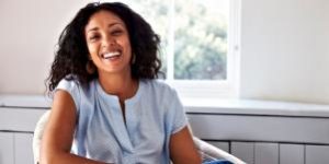 Woman sitting in a chair smiling.